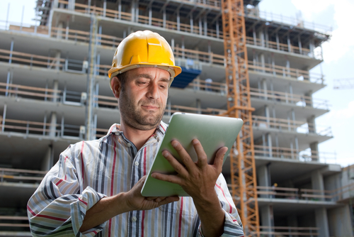 A man in hard hat using a tablet computer.