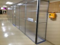 A metal wall with glass doors in the middle of it.