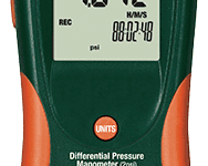 A green and orange meter with an alarm clock.