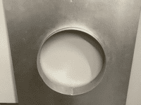 A metal square with a hole in the middle.